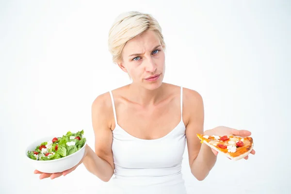 Pretty woman deciding between pizza and salad Stock Image