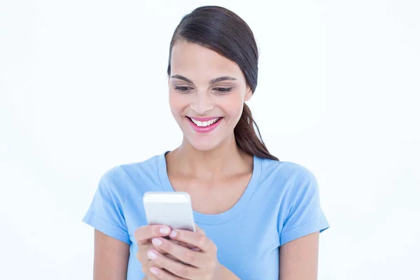 Happy brunette looking at her smartphone Stock Image
