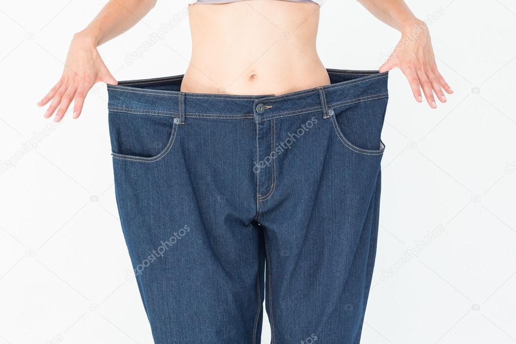 Woman wearing too large pants Stock Photo by ©Wavebreakmedia 73283617