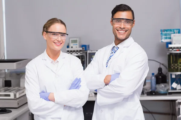 Wetenschappers gekruiste armen van de camera kijken — Stockfoto