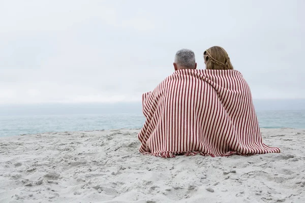 Szczęśliwa para siedzi na plaży — Zdjęcie stockowe