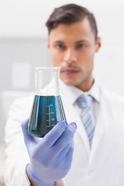 Concentrated scientist looking at beaker — Stock Photo, Image