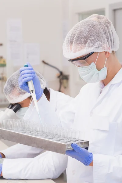 Científico haciendo experimentos en tubos — Foto de Stock