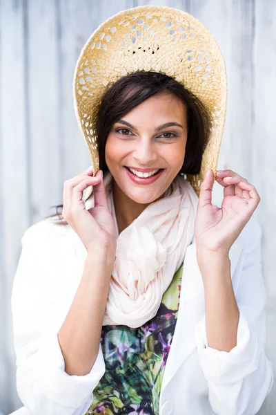 Smiling beautiful brunette wearing straw hat and looking at came — Stock Photo, Image