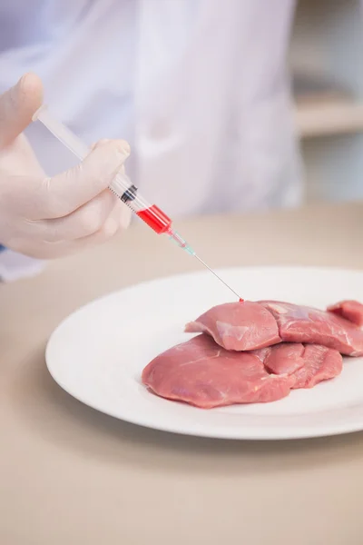 Scientist doing injection to pieces of meat — Stock Photo, Image