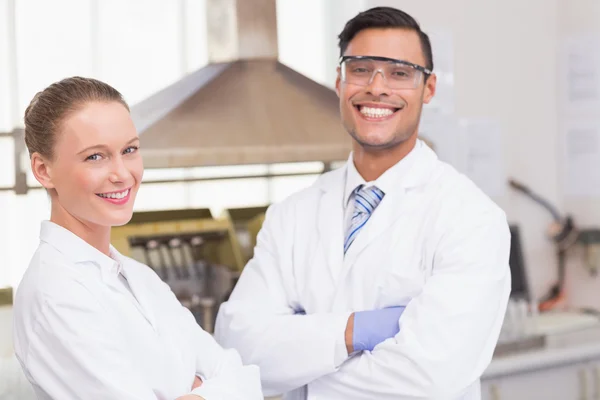 Scienziati sorridenti alla macchina fotografica con le braccia incrociate — Foto Stock