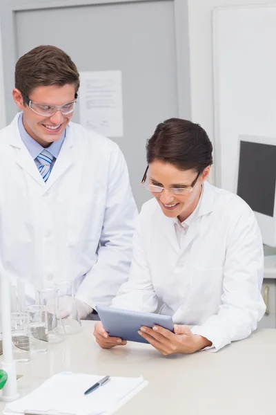 Smiling scientists using tablet — Stock Photo, Image