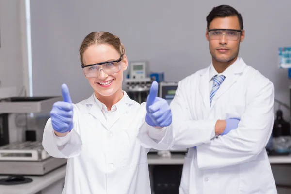 Scientist gives thumbs up with her colleague — Stock Photo, Image