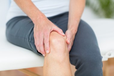 Woman having knee pain clipart