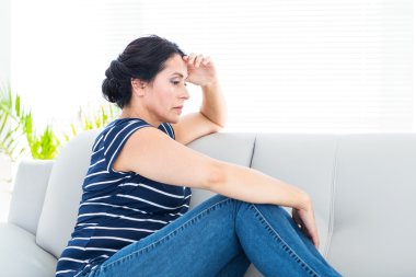 Unhappy woman sitting on the couch clipart