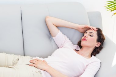 Sad brunette lying on the couch clipart