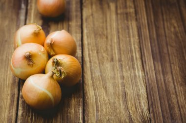 Fresh onions on wooden background clipart