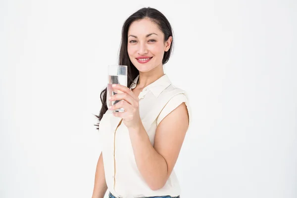 Půvabná brunetka drží sklenici vody — Stock fotografie