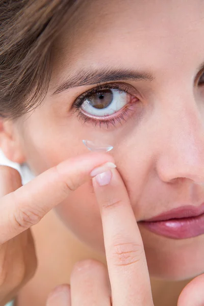 Jolie femme appliquant une lentille de contact — Photo