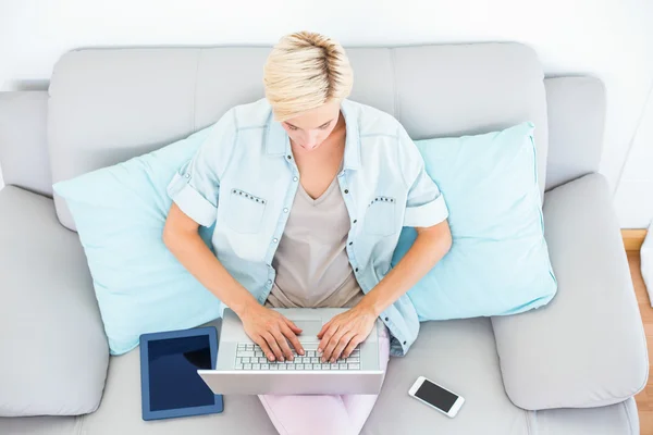 Frau mit Laptop auf der Couch — Stockfoto