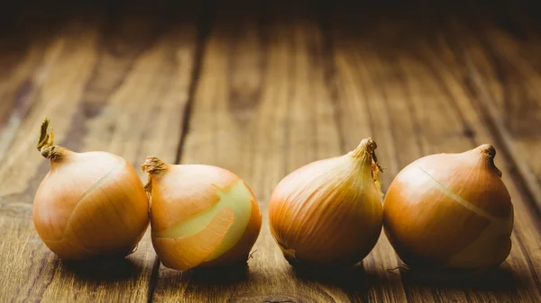 Fresh onions on wooden background — Stock Photo, Image