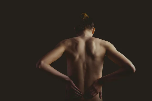 Mulher nua com uma lesão nas costas — Fotografia de Stock