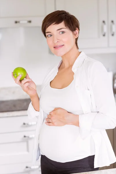 Těhotná žena jíst jablko — Stock fotografie