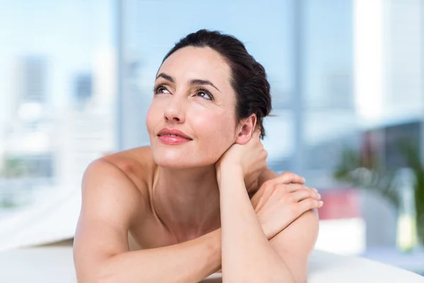 Sorrindo morena relaxante na mesa de massagem — Fotografia de Stock