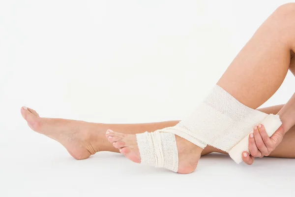 Sitting woman banding her ankle — Stock Photo, Image
