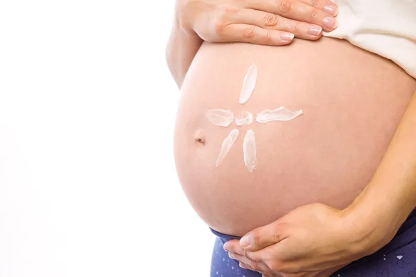 Zwangere vrouw met crème op hobbel — Stockfoto