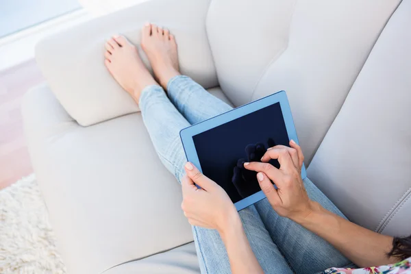 Mulher usando computador tablet no sofá — Fotografia de Stock