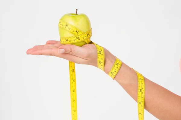 Woman holding apple with measuring tape — Stock Photo, Image