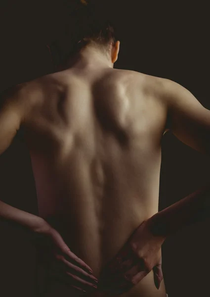 Nude woman with a back injury — Stock Photo, Image
