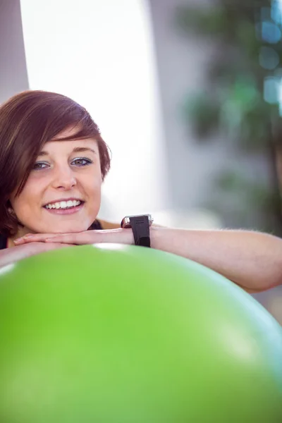 Fit woman leaning on exercise ball — Stock Photo, Image