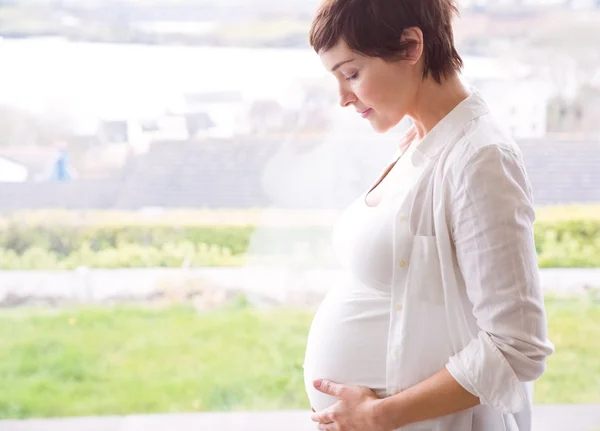 Pregnant woman holding her bump — Stock Photo, Image