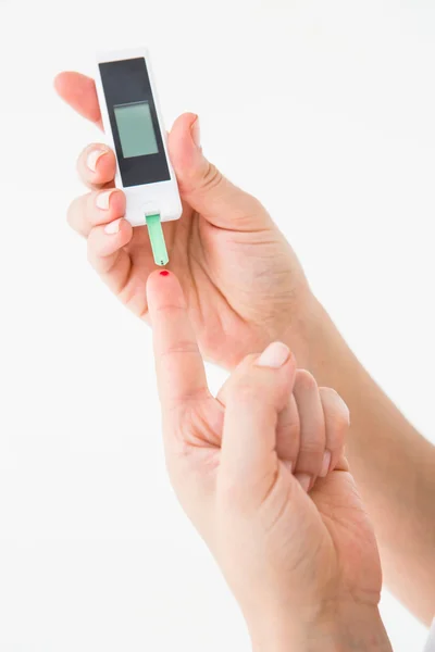 Woman using blood glucose monitor — Stock Photo, Image