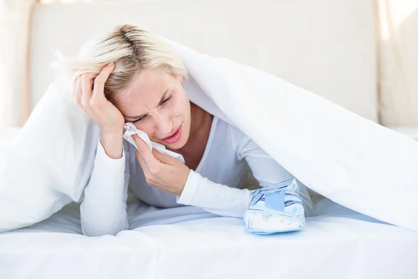 Triest blonde vrouw liggend op bed — Stockfoto