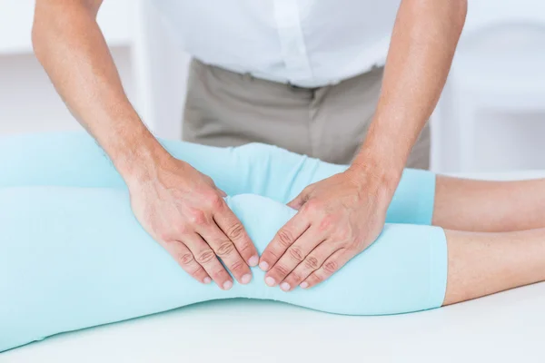 Fisioterapeuta fazendo massagem nas pernas de seu paciente — Fotografia de Stock