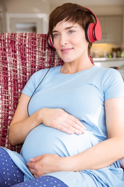 Gravid kvinna lyssna på musik — Stockfoto