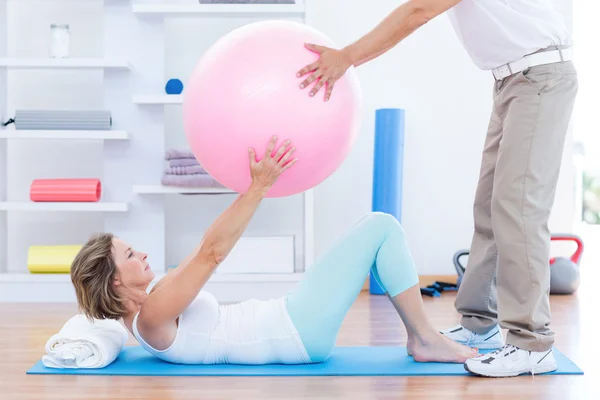 Therapist helping his patient with exercise ball — Stock Photo, Image