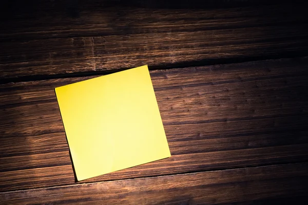 Yellow post it on wooden background — Stock Photo, Image