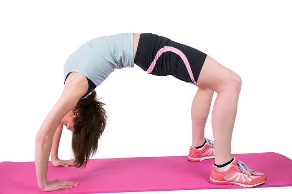 Mooie brunette die zich uitstrekt over Trainingsmat — Stockfoto