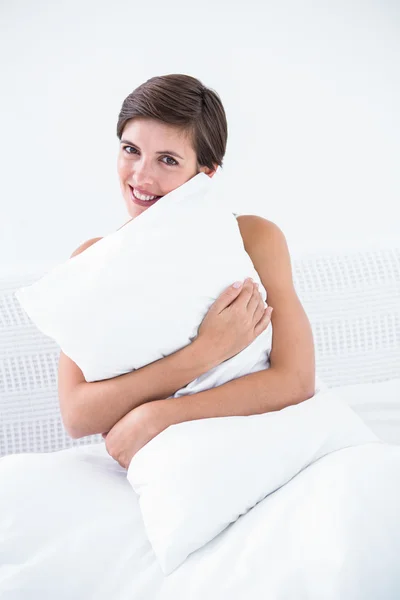 Morena feliz abrazando su almohada — Foto de Stock