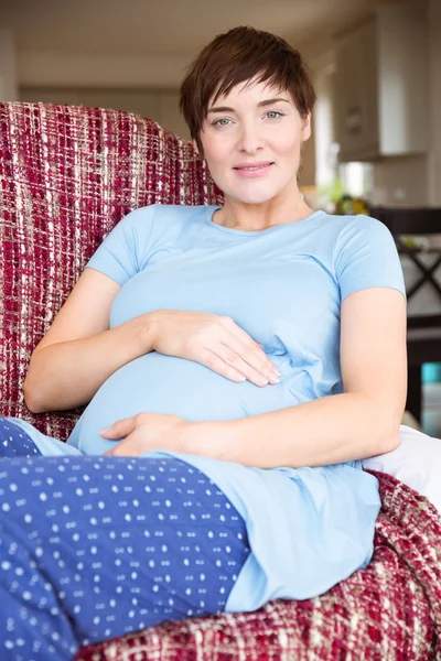 Kobieta w ciąży na kanapie — Zdjęcie stockowe