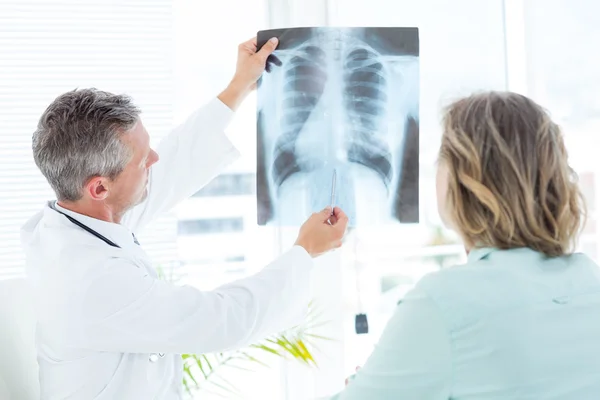 Doctor mostrando rayos X a su paciente — Foto de Stock