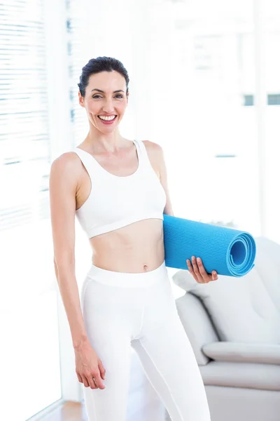 Usměvavá brunetka drží cvičení mat — Stock fotografie