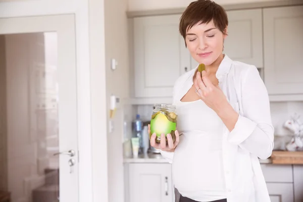 Pregnant woman eating jar of pickles — Stock Photo, Image