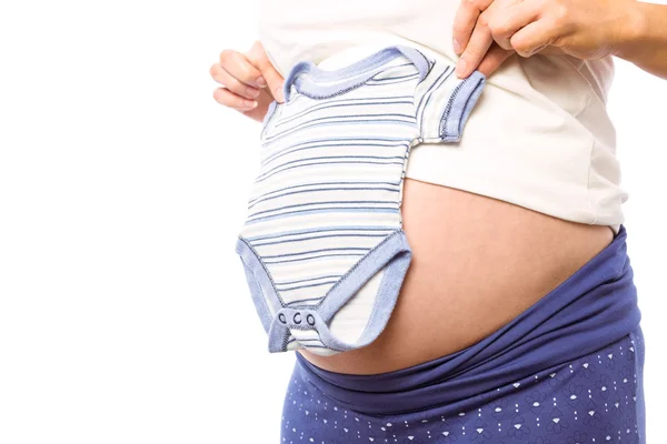 Mulher grávida segurando roupas de bebê — Fotografia de Stock