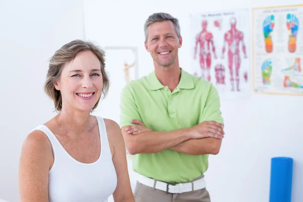 Doctor and patient smiling at camera — Stock Photo, Image
