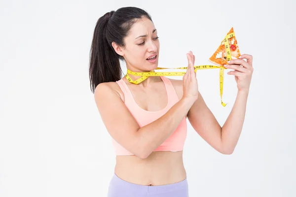 Brunette holding pizza and measuring tape — Stock Photo, Image