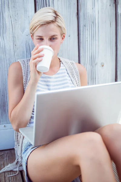 Loira usando laptop e beber café — Fotografia de Stock