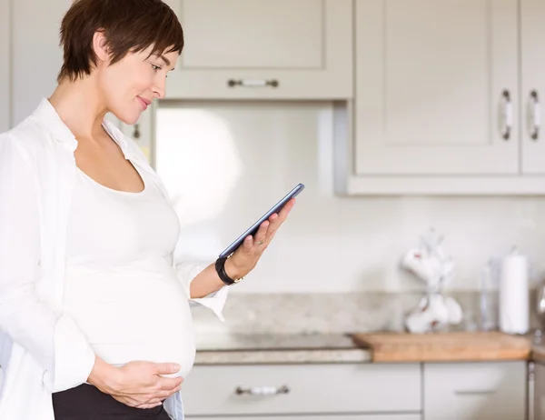 Těhotná žena pomocí počítače tablet pc — Stock fotografie