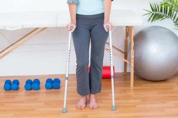 Woman standing with crutch — Stock Photo, Image