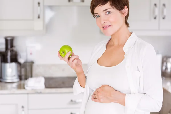 Mulher grávida comendo uma maçã — Fotografia de Stock