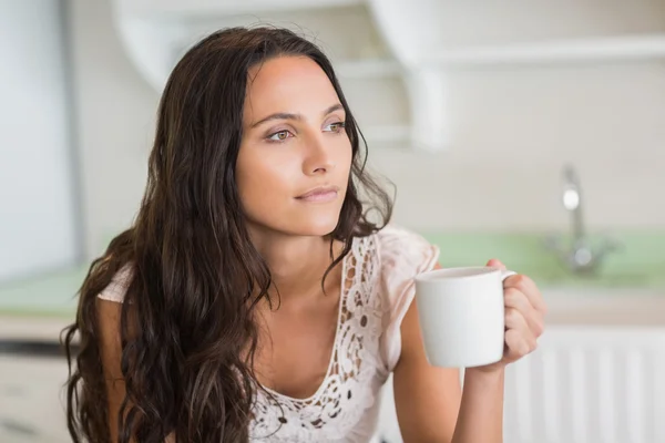 Půvabná brunetka drží hrnek — Stock fotografie